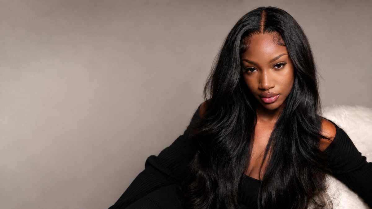 Woman wearing long natural black VB Raw Hair kinky straight human hair extensions styled in a full blowout look